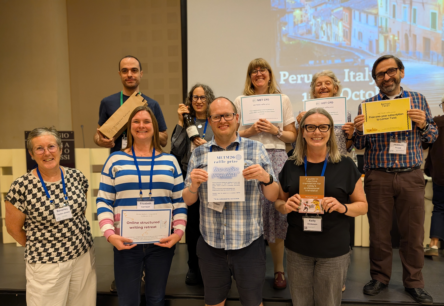 Photo of the 8 raffle winners smiling and holding up their prizes, with the raffle coordinator standing beside them.